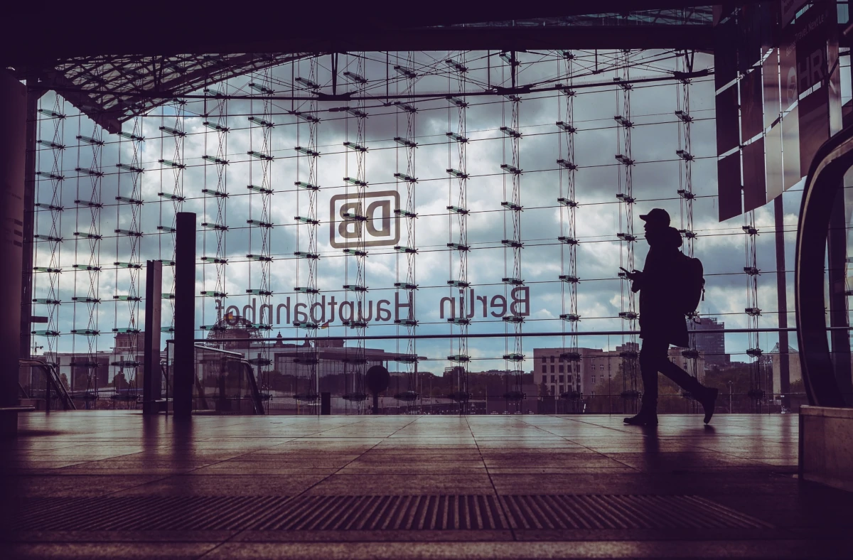 Hauptbahnhof Berlin, Glasfenster, im Vordergrund läuft ein Mensch von rechts nach links