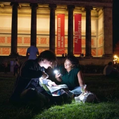 Lange Nacht der Museen Berlin, couple sits with a flashlight in front of the Altes Museum am Lustgarten and watches the program