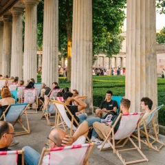 Colonnade bar on Museum Island Berlin, visitors sit in deckchairs with drinks