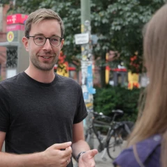 Matti's city tours, city guide Matti talks to a tourist and explains something about Berlin to her