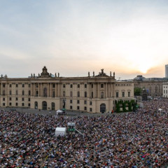 Staatsoper für alle Blick auf den mit Menschen vollen Bebelplatz bei Staatsoper für alle. Im Hintergrund sind verschiedene Gebäude und die untergehende Sonne zu sehen.