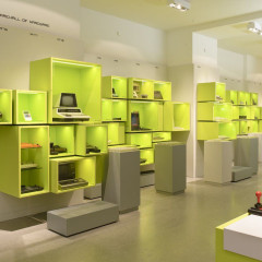 Hardware Wand im Computerspielemuseum Berlin. In verschiedenen grünen Kisten sind die unterschiedlichen Stationen der Computergeschichte dargestellt.
