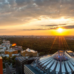 Blick vom Panoramapunkt in den Sonnenuntergang über das Sony Center und den Tiergarten im Hintergrund. Berlin Skyline.