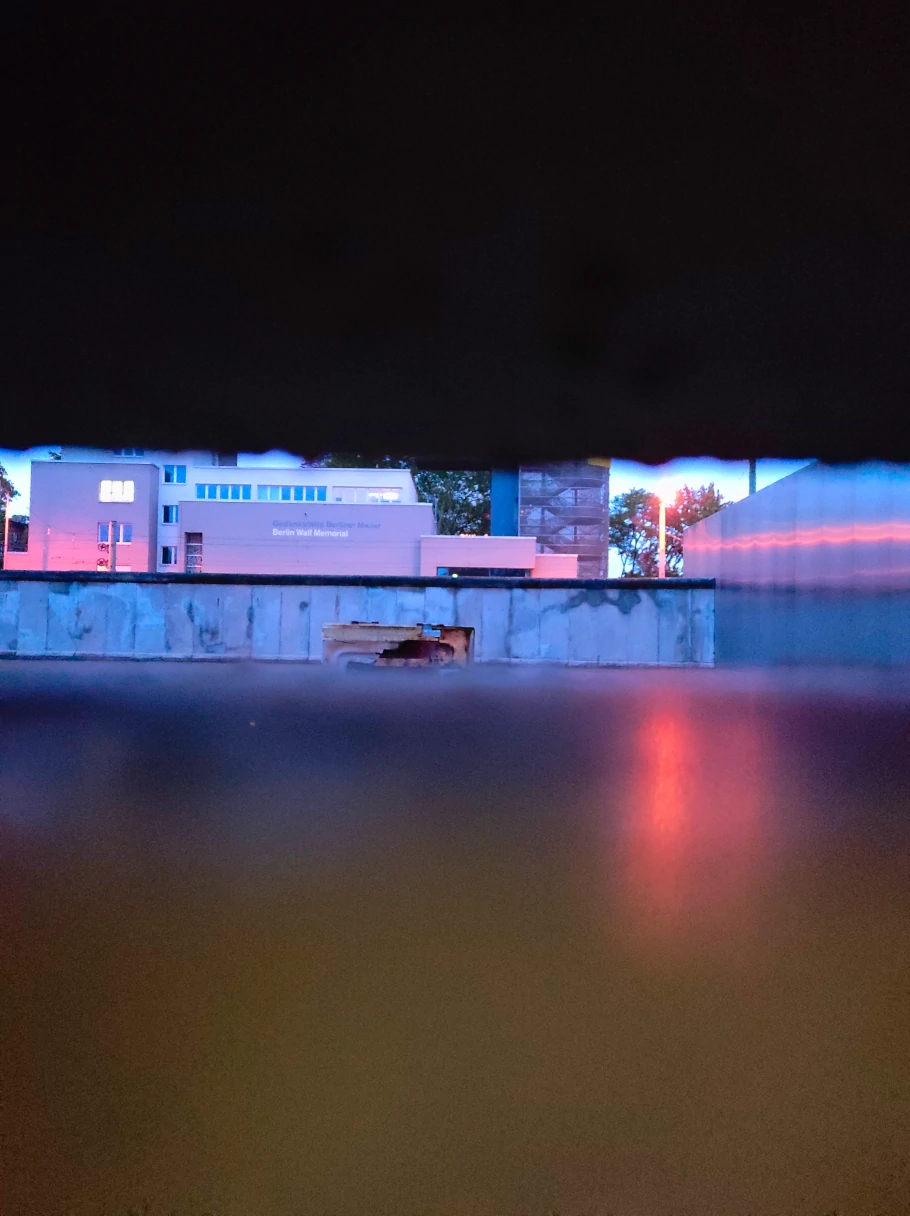 View through a gap in the Wall at the Berlin Wall Memorial. You can see the building of the Berlin Wall Memorial on the other side.