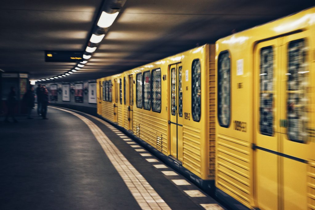 gelbe U-Bahn fährt in den U-Bahnhof ein