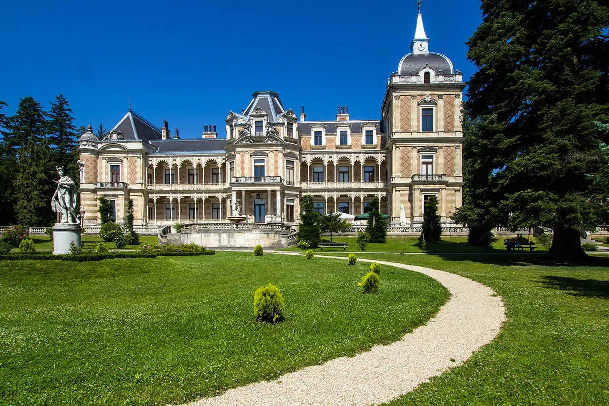 Hermesvilla, grüne Wiese, Kiesweg der zur Villa führt, blauer Himmel, Sonnenschein