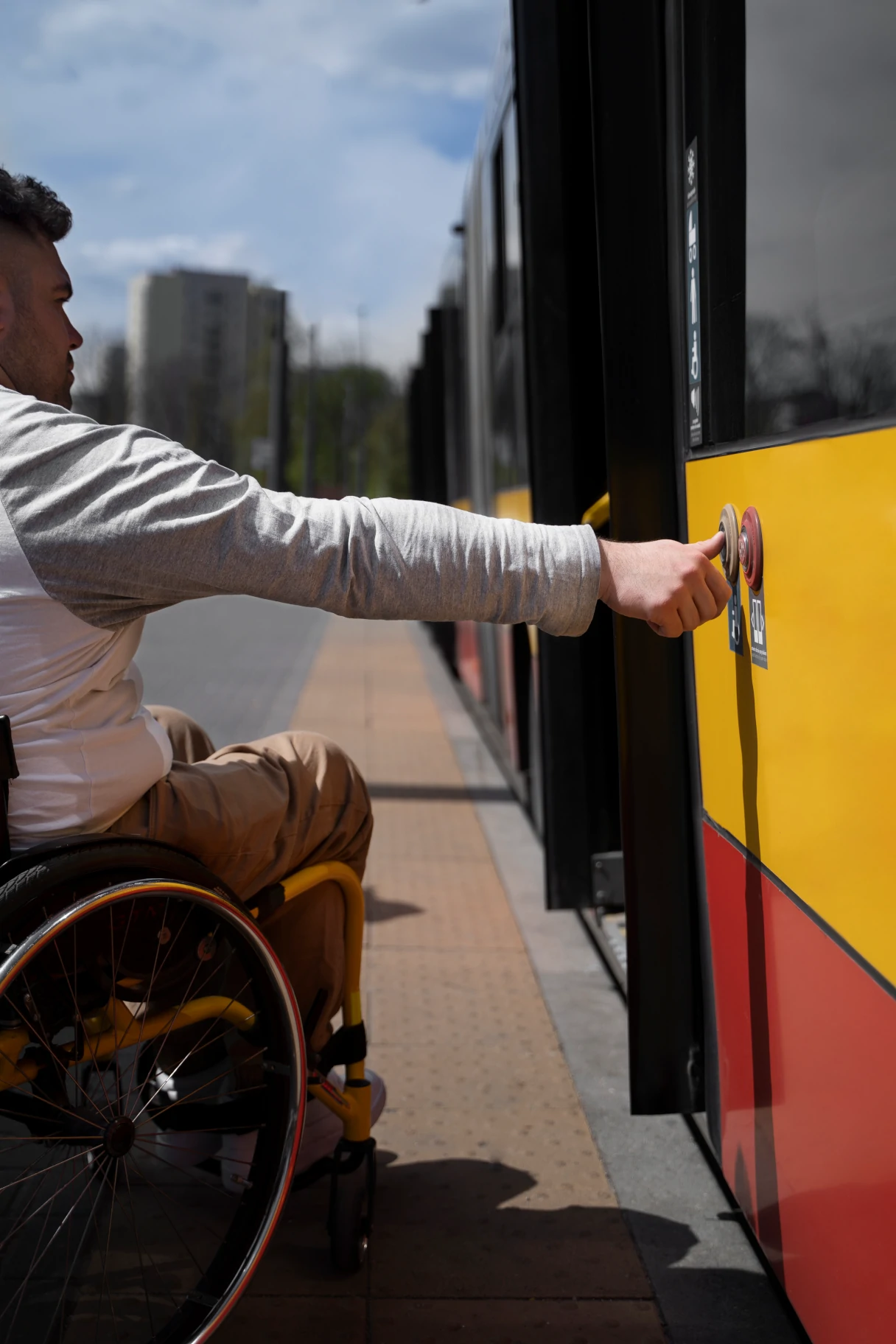 Man in a wheelchair wants to get on the streetcar and presses the door button