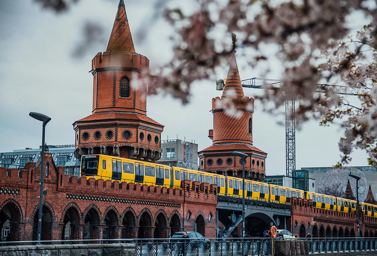 Oberbaumbrücke, Berlin, Kirschblüten, gelbe U-Bahn fährt über die Oberbaumbrücke rüber, roter Klinkerbau