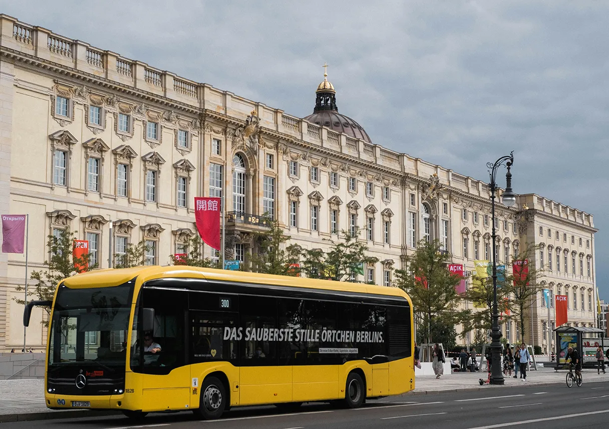 gelber BVG Bus fährt vor dem Humboldtforum Schloss in Berlin vorbei