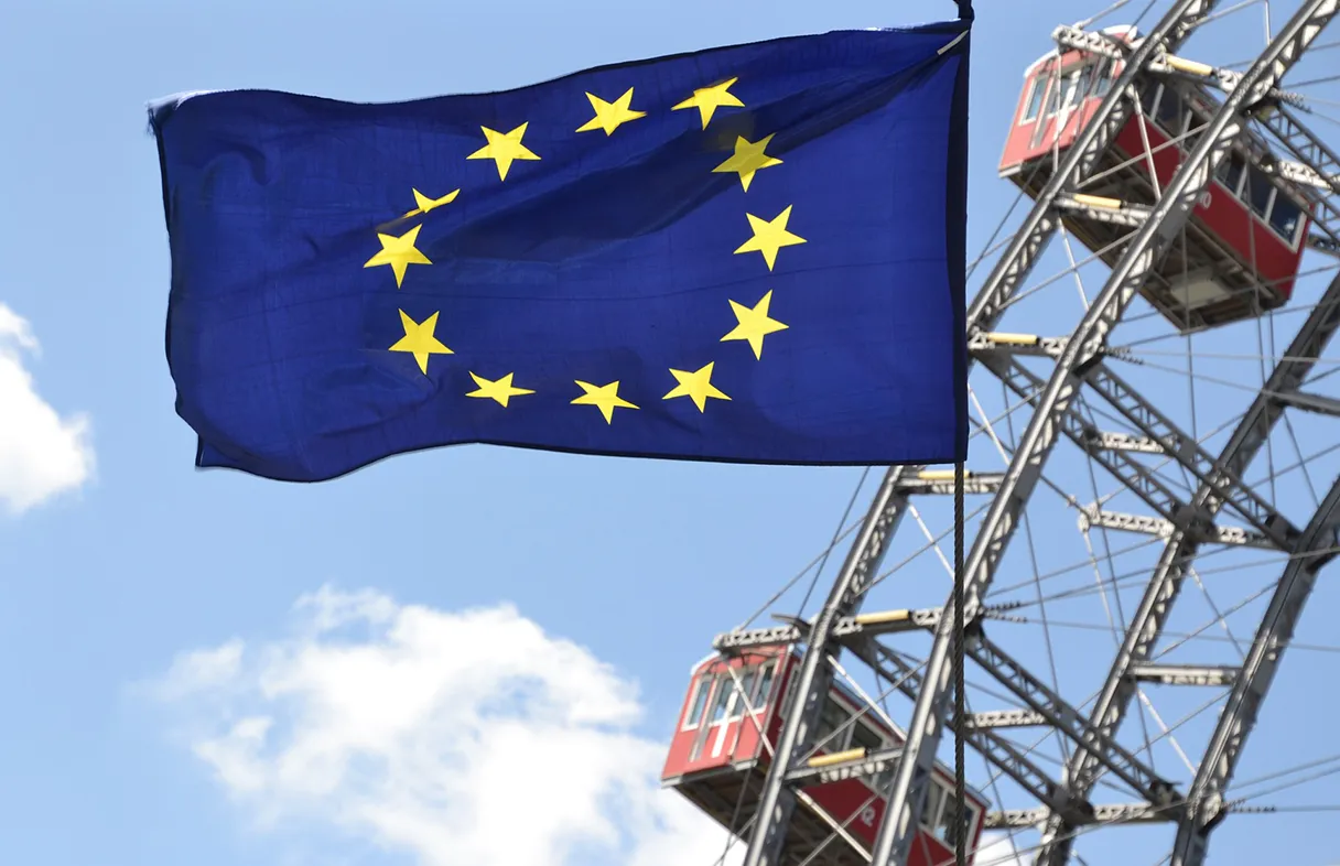 Europaflagge im Vordergrund, im Hintergrund ist das Wiener Riesenrad zu sehen