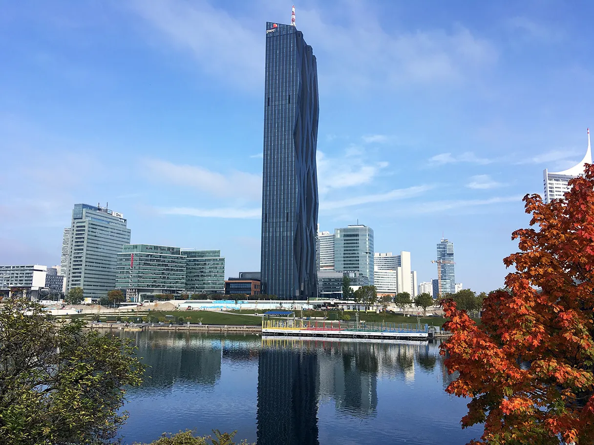 View of UNO City, small lake in the foreground, in which the buildings are reflected