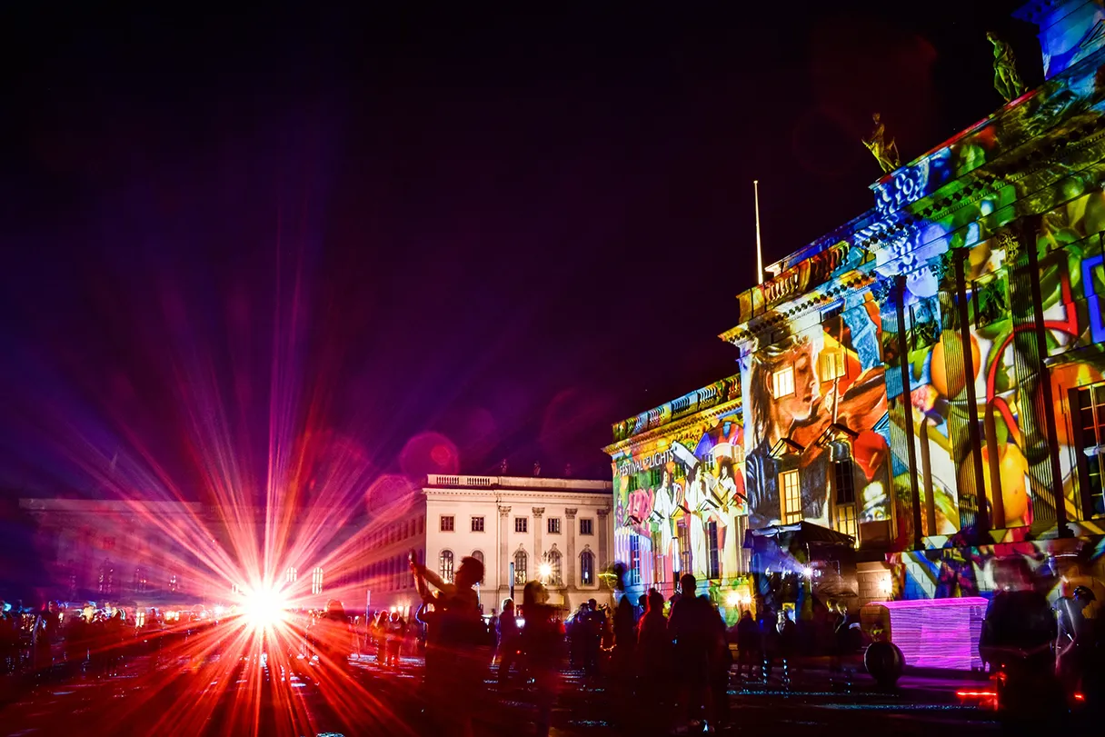 Festival of Lights Berlin, Bebelplatz, Staatsoper Berlin wird bunt angeleuchtet, ein großer Strahler wirft pinke Lichtstrahlen über das gesamte Bild
