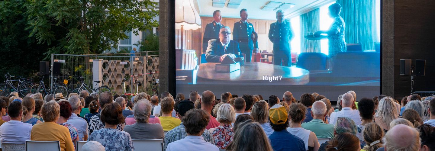 Campus-Kino, Stasi-Zentrale, Blick auf die Leinwand, Publikum sitzt auf Stühlen vor der Leinwand