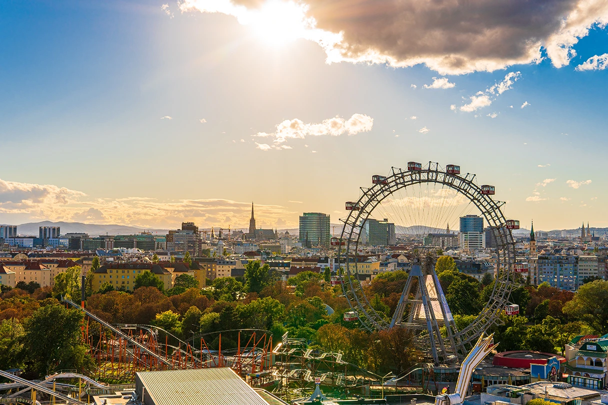 Sommer in Wien, Blick auf den Wiener Prater, Achterbahnen, Fahrgeschäfte, Sonne scheint durch ein paar Wolken