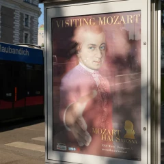 Mozarthaus Vienna, Vienna, poster on the street, streetcar passes by in the background