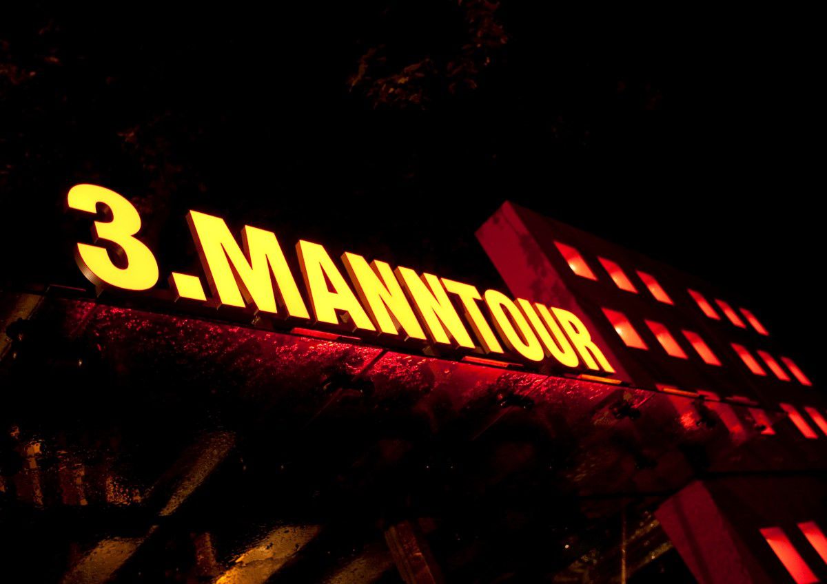 3. Mann Tour, Eingangsbereich, gelbe Leuchtbuchstaben ergeben das Wort 3. Manntour