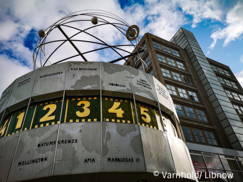 World time clock at Alexanderplatz, 1 to 5 o'clock can be seen, white clouds in blue sky
