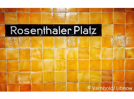 Rosenthaler Platz, U-Bahnhof, orangene Kacheln, schwarzes Rosenthaler Platz Schild