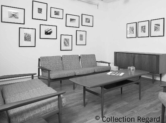 Salon Photographique, schwarz weißes Bild, Raum mit Couchtisch, Sofa und Bildern an der Wand