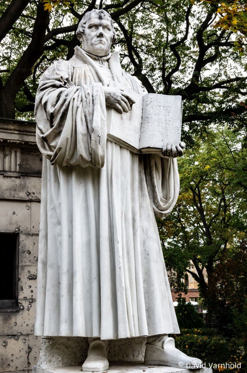 Luther Denkmal, Luther steht und hat ein Buch in der Hand