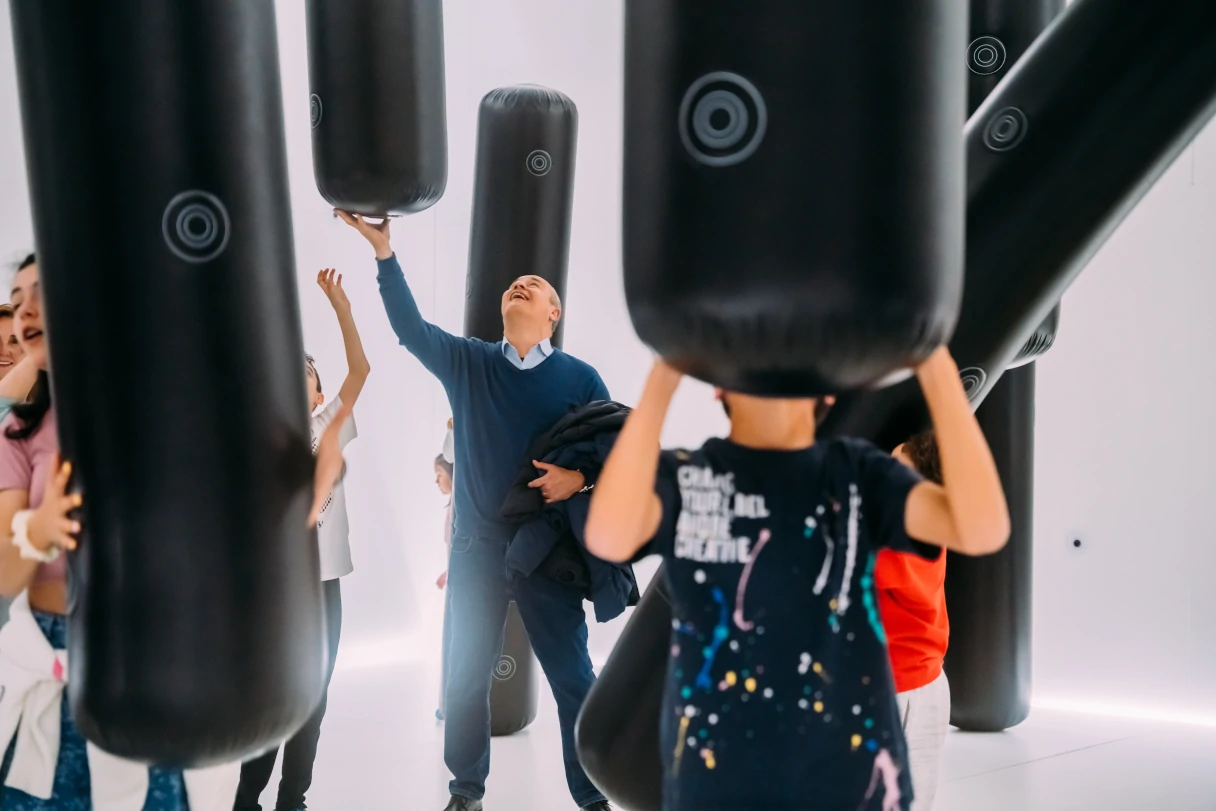 Punching bags hang from the ceiling and move. Visitors to the museum try to catch them.