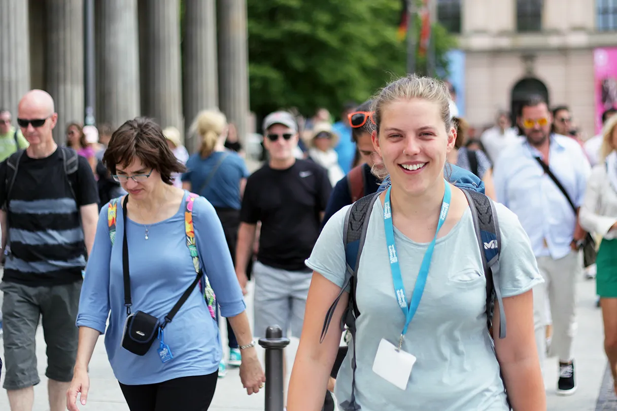 Original Berlin walks, woman with blue Original Berlin walks ribbon around her neck leads her group through Berlin