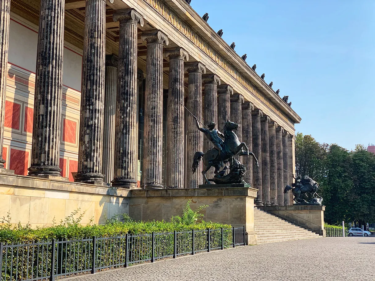 Original Berlin walks, Blick auf das Alte Museum mit verschiedenen Säulen und Statuen davor, Abendsonne strahlt das Museum auf der Museumsinsel an