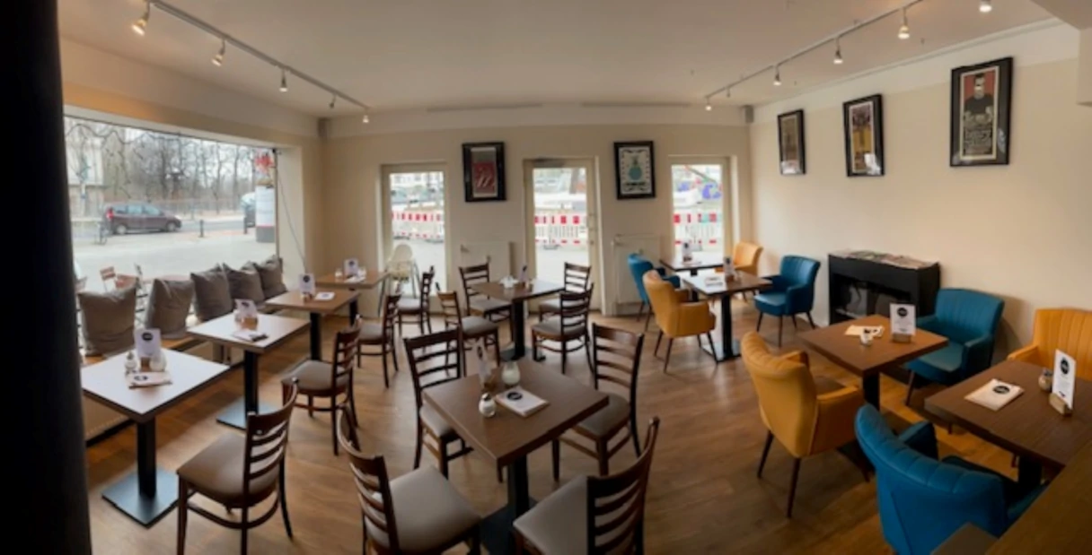 Café La Mouche, Blick in den Innenbereich, Stühe und Tische, gemütliche Sitzecke mit Kamin
