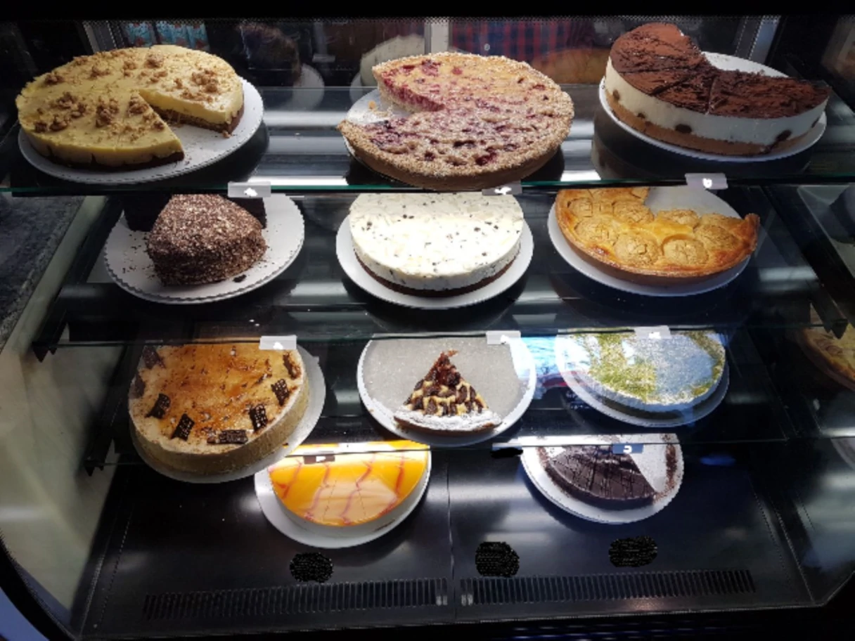 Café La Mouche, Vitrine mit drei Etagen in der verschiedene Torten und Kuchen stehen