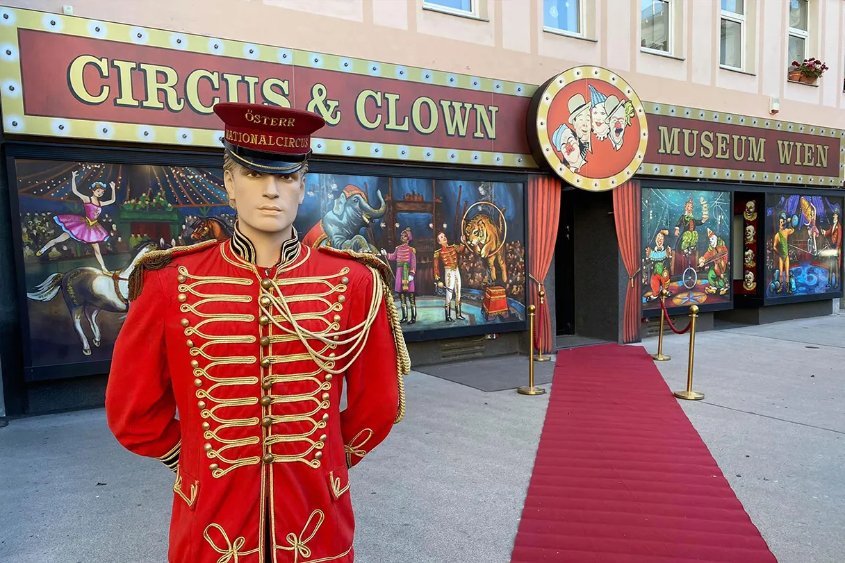 Circus & Clownmuseum Wien, roter Teppich und Puppe in roter Zirkusdirektoruniform, Eingangsbereich von Außen