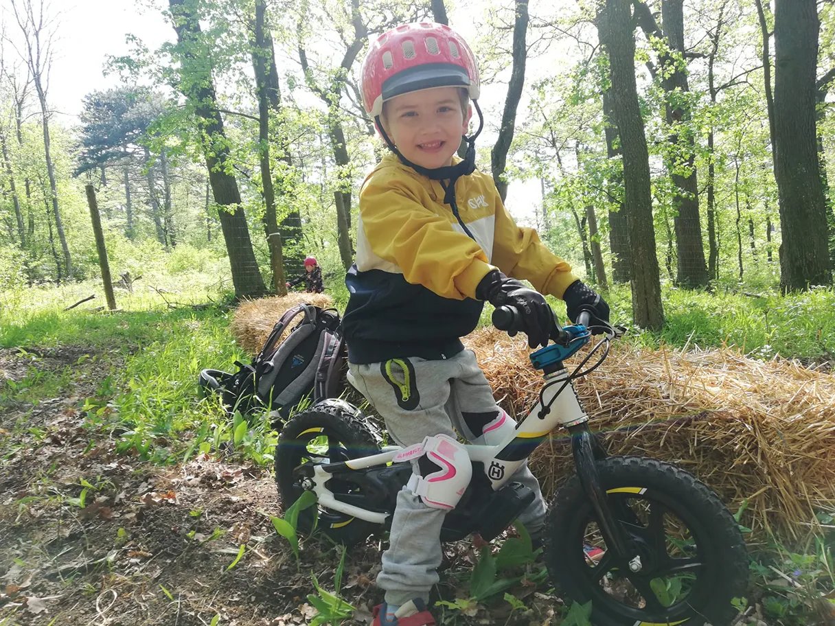 Erlebniswelt Kahlenberg, e-balance biking, child on an e-bike in the forest, looking into the camera