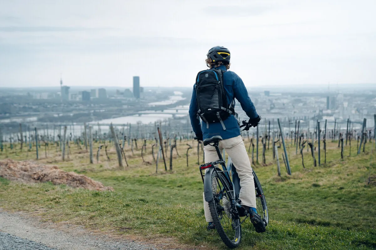 Erlebniswelt Kahlenberg, E-Mountain bike, Radfahrer steht neben den Weinbergen