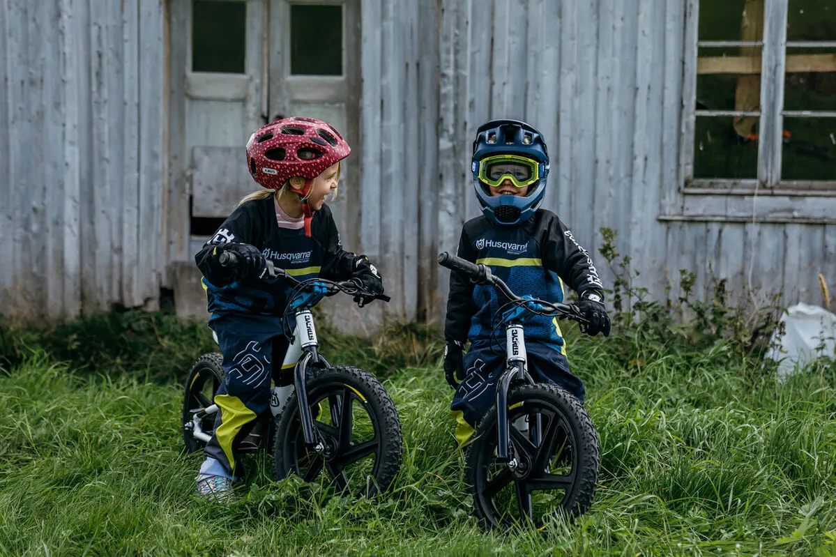 Erlebniswelt Kahlenberg, e-balance biking, two children sit on their e-balance bikes in front of a hut on the green lawn