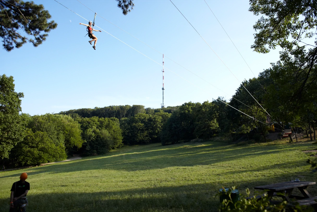 Besucher hängt an einem Seil, Flying Fox, schwebt über eine Wiese