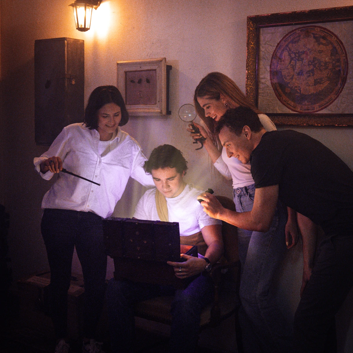 Escape mission, Vienna, four people stand around a laptop with a flashlight, trying to solve puzzles