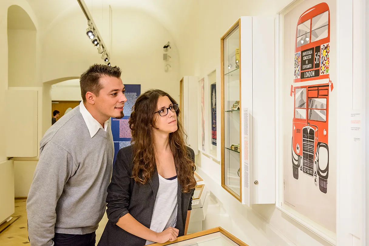 Esperantomuseum, Wien, Frau und Mann stehen im Museum und schauen sich vershiedene Ausstellungsstücke an