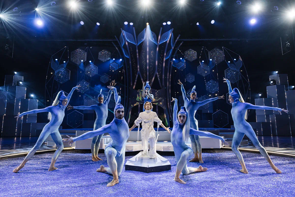 Friedrichstadt-Palast Berlin, Falling in Love, The blue garden, Tänzer in blauen Kostümen stehen in Formation um eine Tänzerin in weißem Kostüm herum