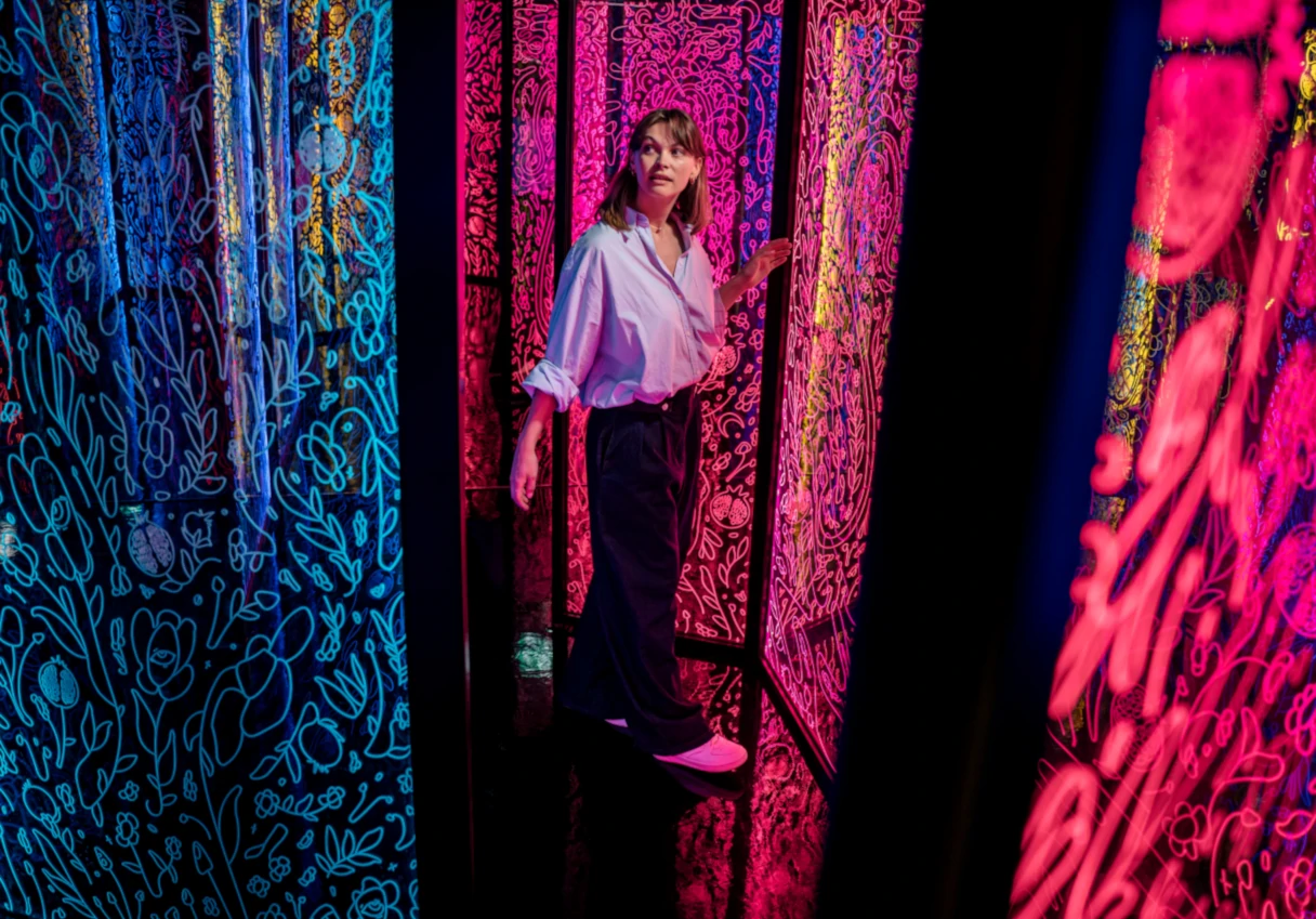 IKONO Vienna, woman runs through a colorful mirror labyrinth