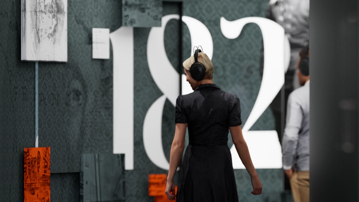 A visitor with headphones on walks through the exhibition at the Johann Strauss Museum. On the wall is written in white 182.