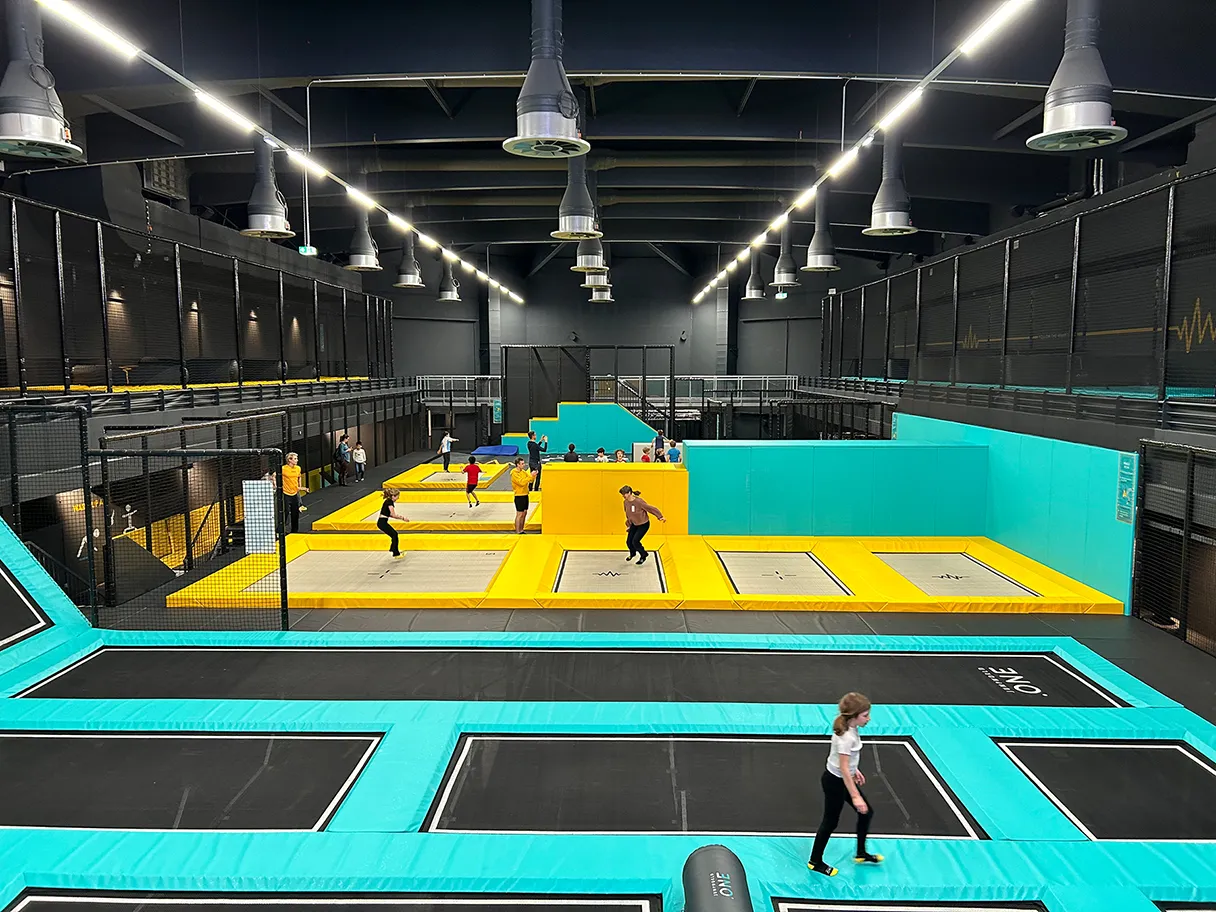Trampoline hall Jumpworld One, various trampoline fields in turquoise and yellow, view into the hall