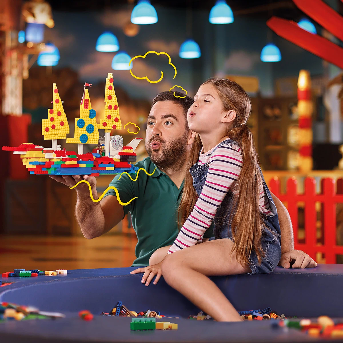 LEGOLAND® Discovery Centre Berlin, Vater und Tochter spielen mit Legosteinen und haben eine bunte Schiffswelt kreiert