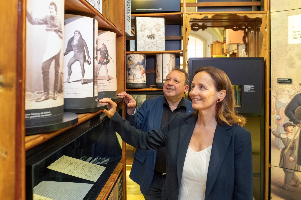 Literaturmuseum Wien. Lächelnde Besucher schauen sich die verschiedenen Ausstellungsexponate an.