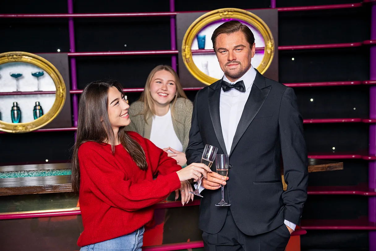 Leonardo DiCaprio, Madame Tussauds Wien, Besucherin stößt mit einem Glas Sekt mit Leonardo DiCaprio an