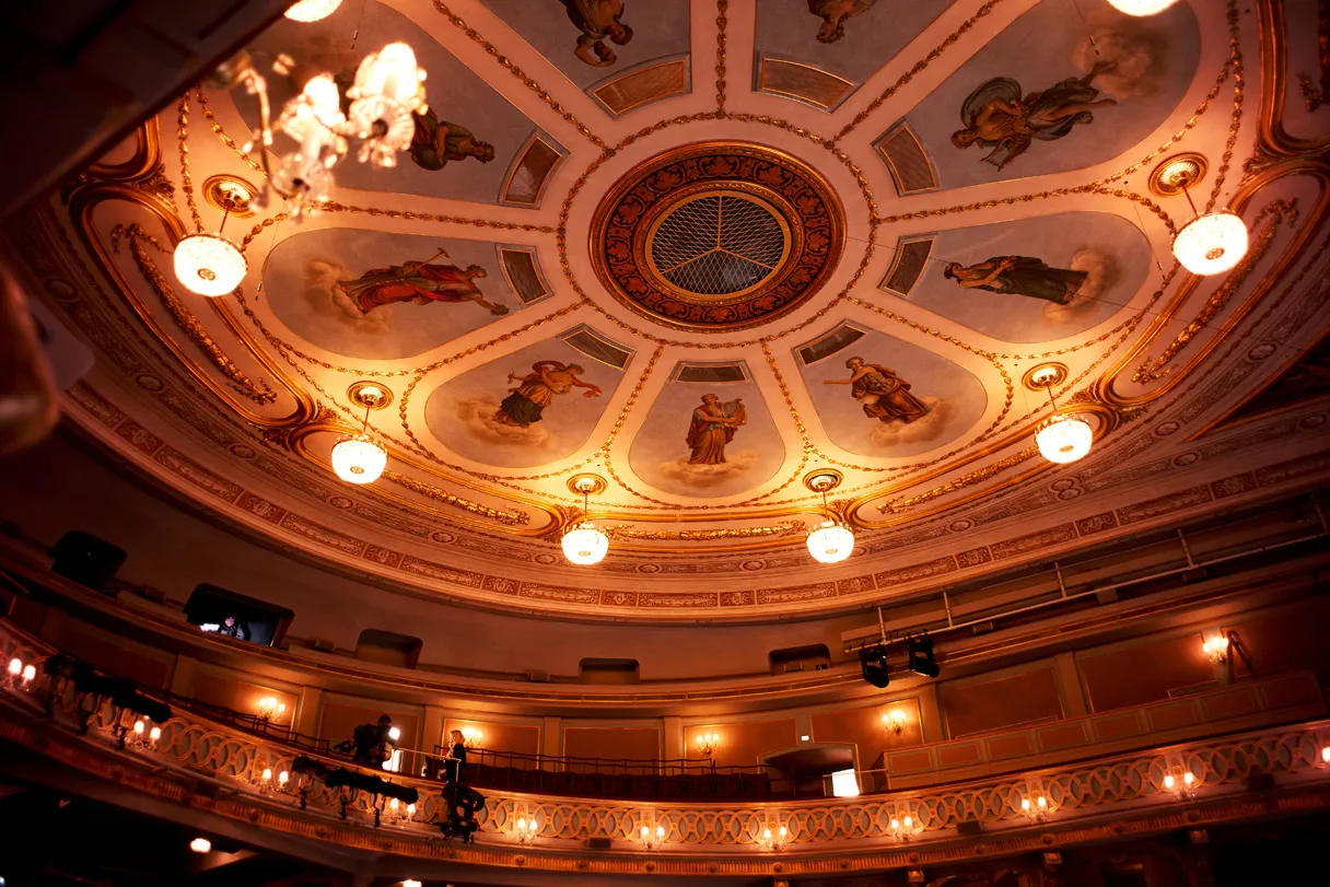 View of the dome of the Theater an der Wien. Lamps and pictures give the impression of a round dome. In order to preserve the unique history and aura of the Theater an der Wien, the historic building has been extensively renovated since March 2022. The result is one of the most modern opera stages, which meets the highest standards and requirements for the safety and comfort of visitors, artists and staff and guarantees contemporary, modern performance operations in the long term.