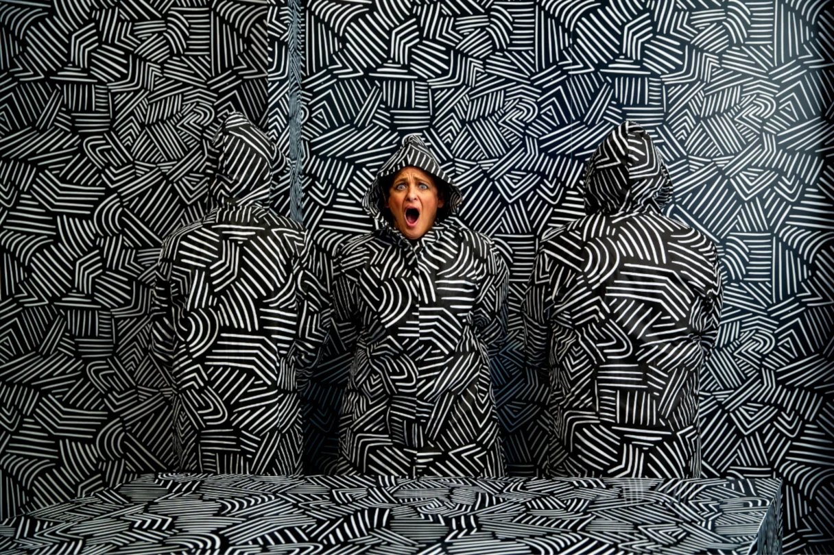 Paradox Museum Berlin, schwarz weißer gemusterter Hintergrund, Frau ist fast nicht zu sehen, nur der Kopf, sie schreit und hat den Mund offen