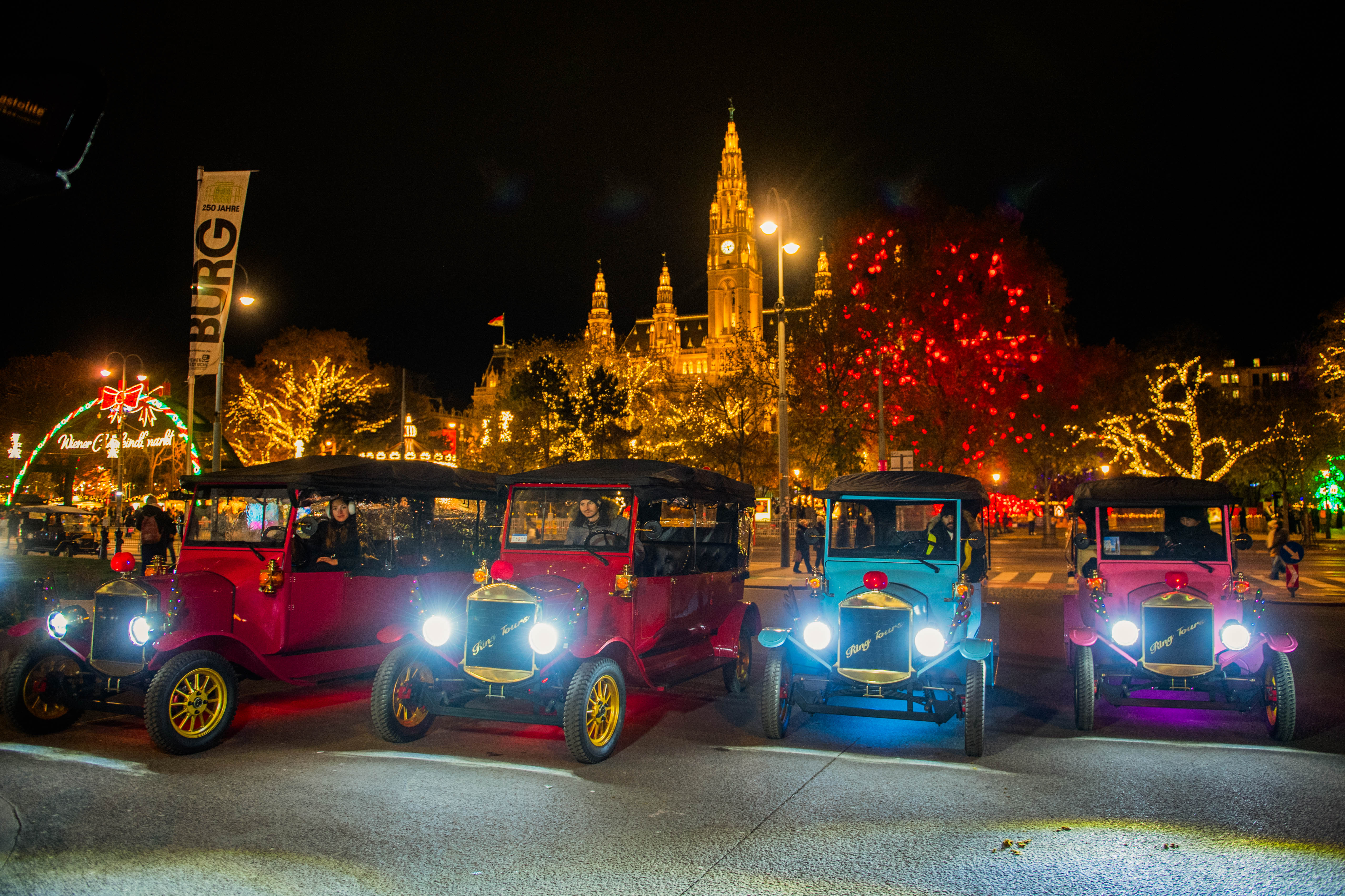 Christmas tours with Ring Tours Vienna. Four vintage cars are parked side by side in front of Vienna's City Hall Square.