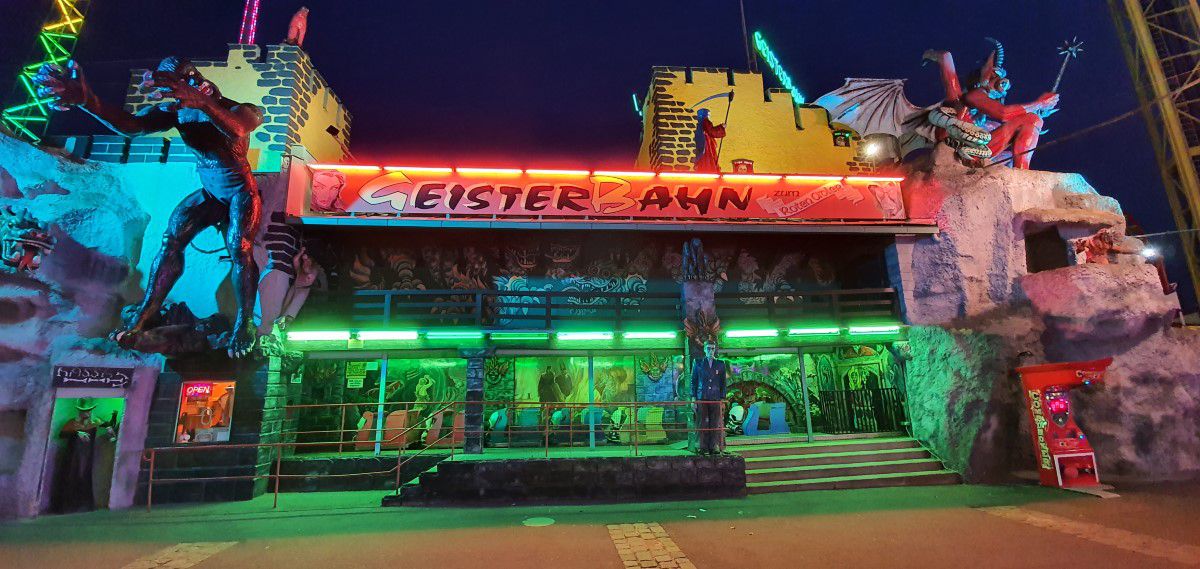 Geisterbahn zum Roten Adler, Wiener Prater, Außenansicht, abends, bunt beleuchtet