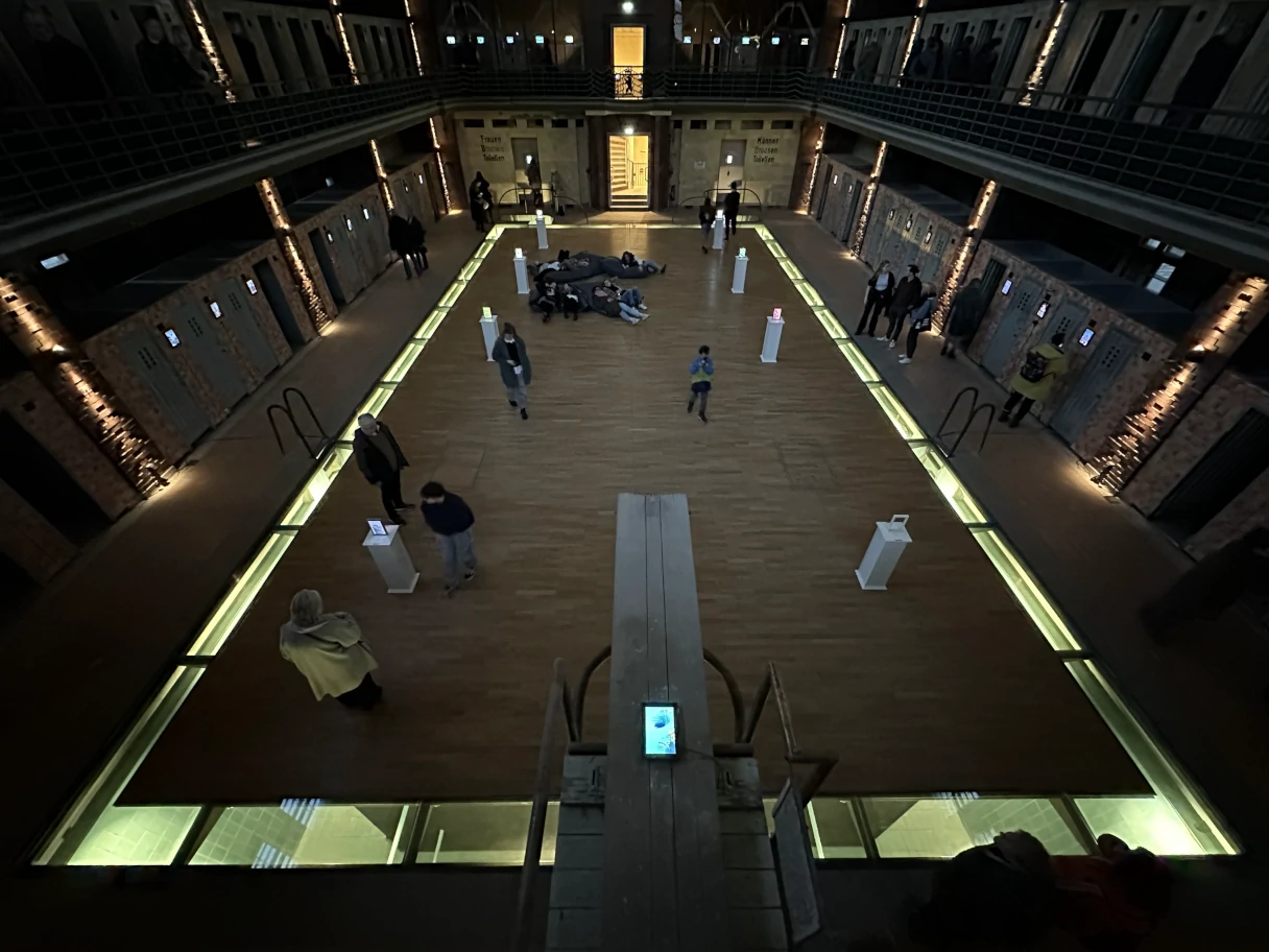 Stadtbad RELOADED: AMBILIGHT, view into the old swimming pool, dark room, the edges are illuminated, people move through the room