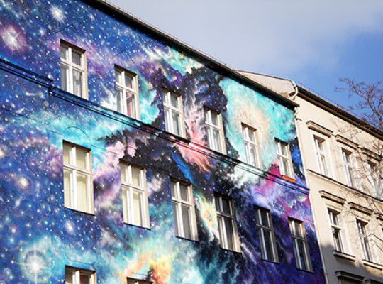 Street art, house wall is painted like the universe
