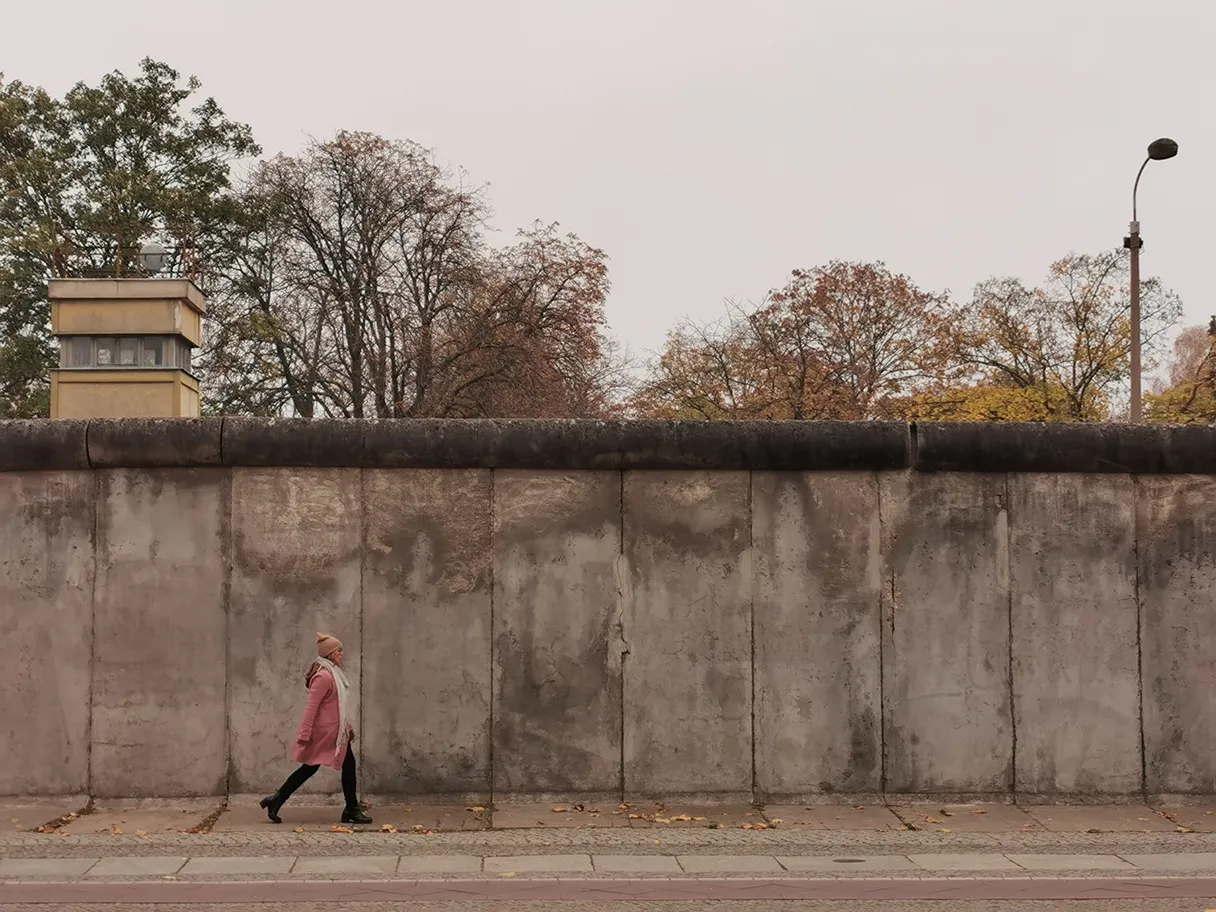 Birgit L. walking along in front of Berlin Wall, autumn day